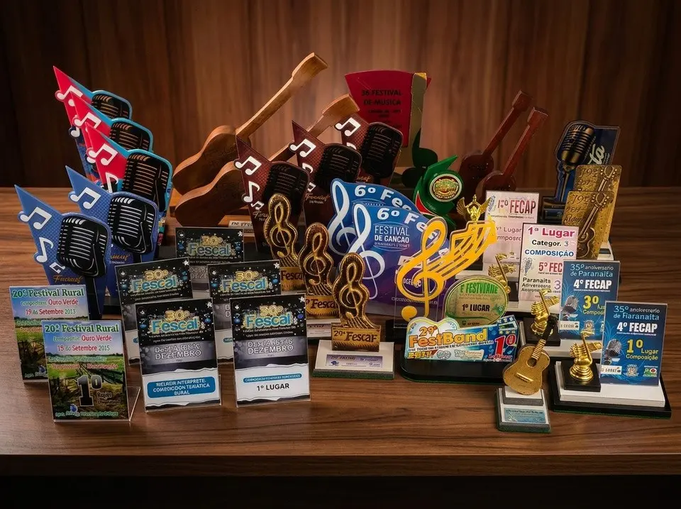 Coleção de troféus de festivais de Lôids sobre uma mesa de madeira